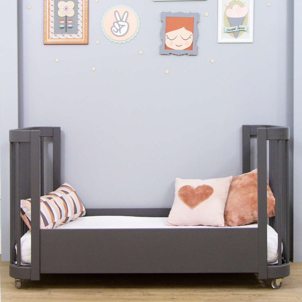 Mini Cama Evolutiva, no quartinho de menina. parede em tom lilás e com quadros