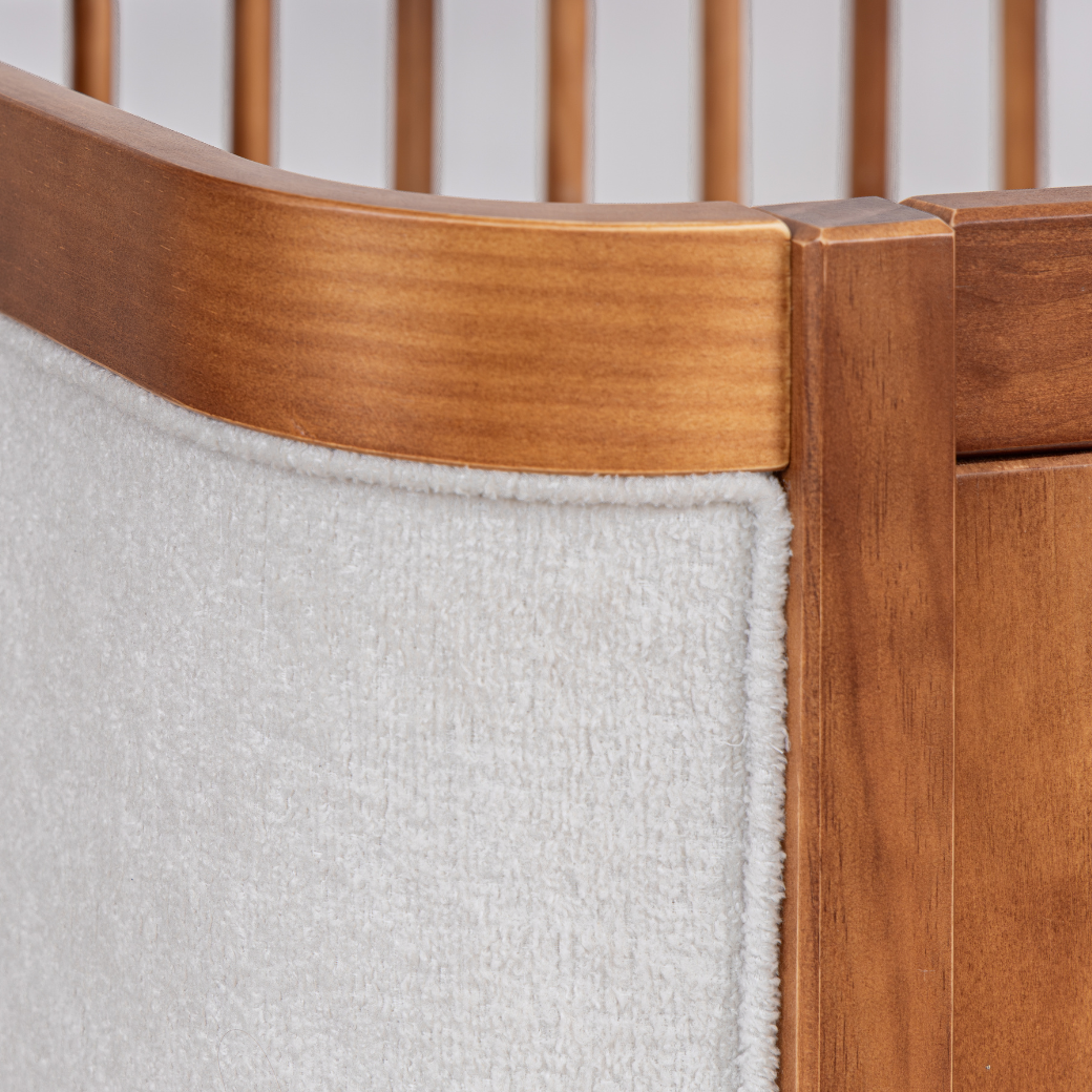 Detalhes do berço de madeira e do tecido bouclé.