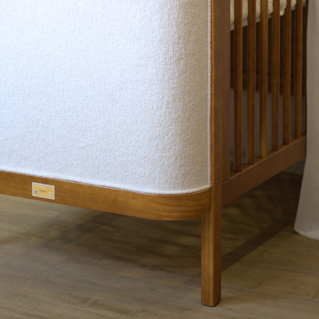 Detalhe dos pés do Berço Soley, Berço de Madeira Maciça com cabeceira estofada.