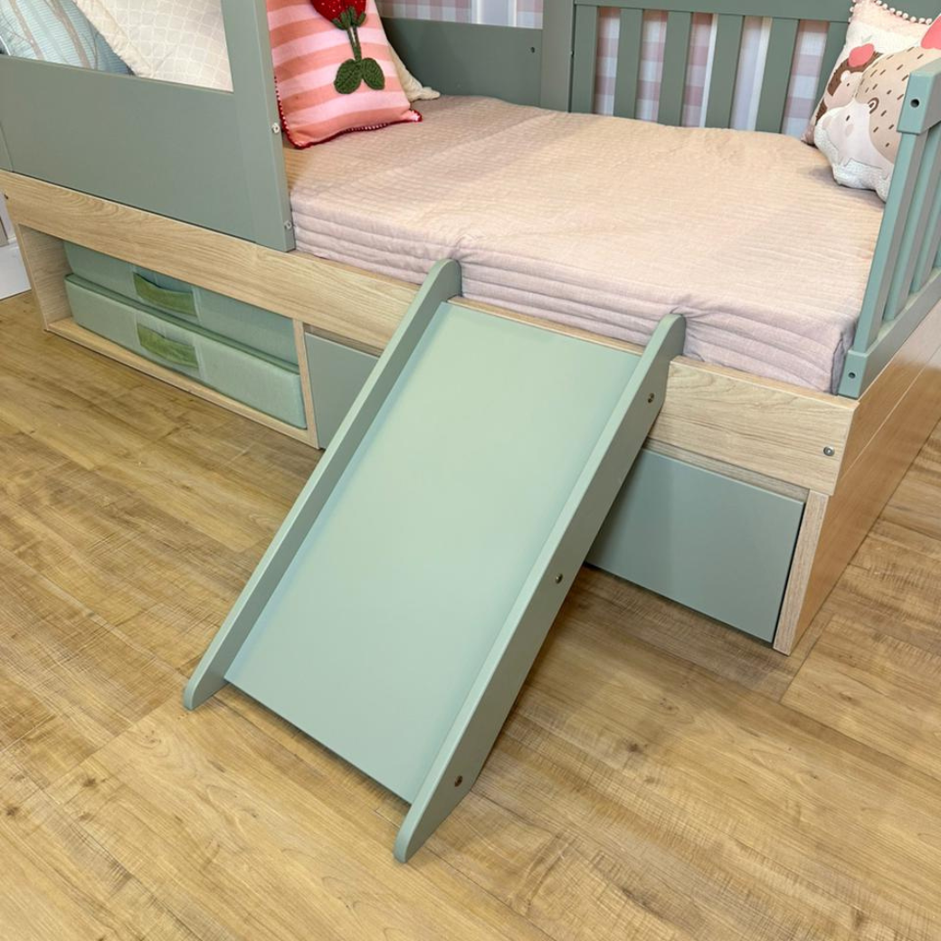 Quarto com uma cama infantil e escorregador verde.